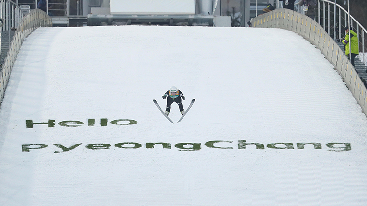 Ski jumper with Hello PyeongChang in the background