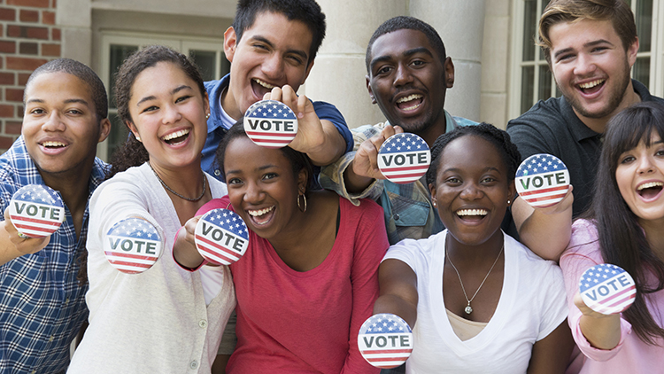 Estudiantes sosteniendo botones en el registro de votantes