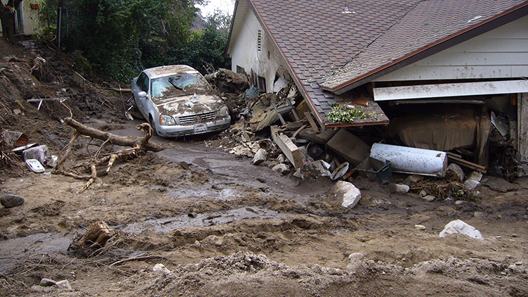 a house and a car damaged by a mudslide