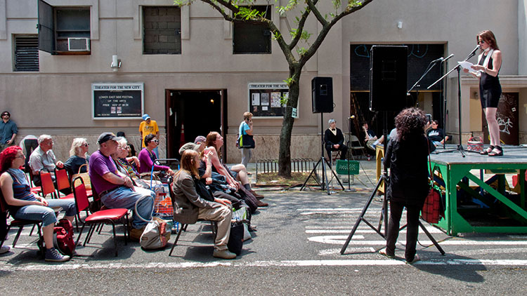 A woman reads an original poem to an audience