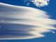 wispy cloud with thin green, blue, purple, and orange streaks on its edges