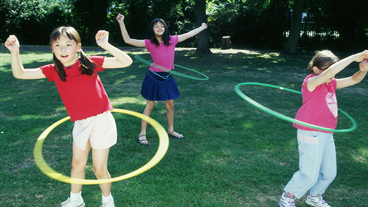 Children spinning a toy hoop around their waists