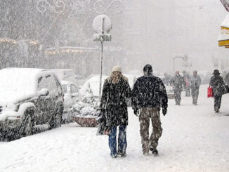 Gente caminando por las aceras de una ciudad durante una nevada.